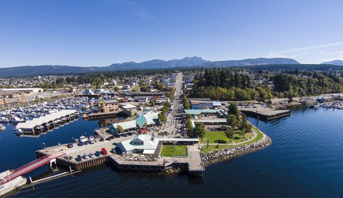Le lac Sproat près de Port Alberni, rive boisée et montagnes enneigées au loin